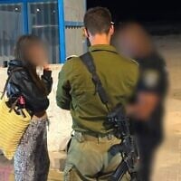An off-duty IDF servicewoman speaks with Israeli security forces after being extracted from the West Bank city of Jericho, July 10, 2026. (Civil Administration)