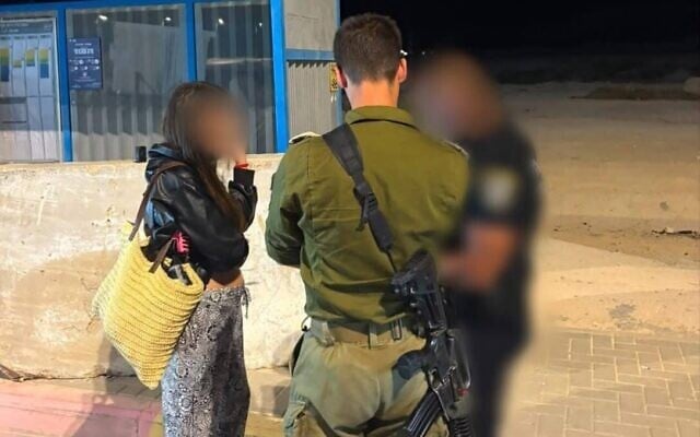 An off-duty IDF servicewoman speaks with Israeli security forces after being extracted from the West Bank city of Jericho, July 10, 2026. (Civil Administration)