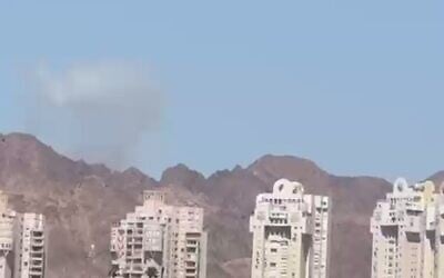 A plume of smoke is seen in the distance from Eilat after an Iranian missile attack on Jordan on July 22, 2026. (Screen capture: Telegram)