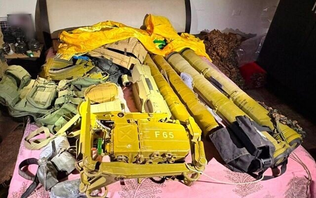Weapons and a Hezbollah flag uncovered by Israeli troops in a civilian home in the southern Lebanese village of Tallousa, July 7, 2026. (Israel Defense Forces)