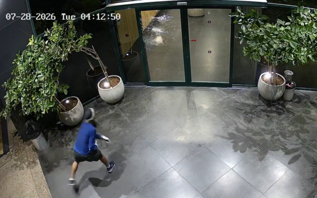 A masked assailant is caught on surveillance footage hurling a brick at the glass doors of Channel 12's offices in Tel Aviv, in the early hours of July 28, 2026. A masked assailant is caught on surveillance footage hurling a brick at the glass doors of Channel 12's offices in Tel Aviv, in the early hours of July 28, 2026. (Channel 12 via X)
