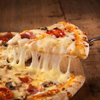 A slice of pizza. Beta-casein, successfully engineered into a plant at Jerusalem's Hebrew University, is one of the milk proteins responsible for making cheese melts. (Proformabooks, iStock by Getty Images)