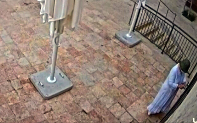 CCTV footage shows a masked individual gluing lock of Basimta cafe in Jerusalem, August 15, 2026. (Screen grab/Channel 12 via X)