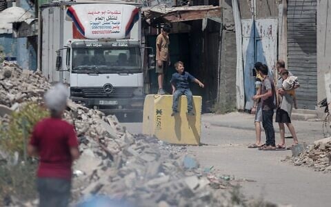 Palestinian children play on a concrete block meant to mark the Israel-expanded Yellow Line in the Shuja'iyya neighborhood of eastern Gaza City on July 26, 2026. (Mohammed M. Skaik / JNA Press/Sipa USA via Reuters)