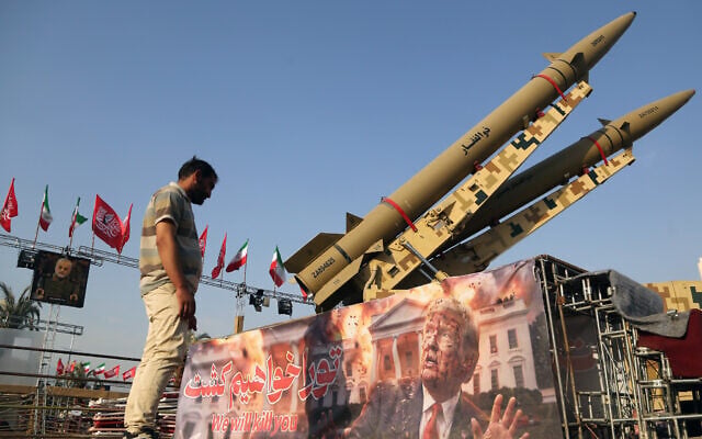 A man looks at a banner depicting US President Donald Trump displayed in front of the Zolfaghar and Zolghadr ballistic missiles exhibited at Azadi Square in Tehran, Iran's capital, on August 2, 2026. (Fatemeh Bahrami / Anadolu via Reuters)