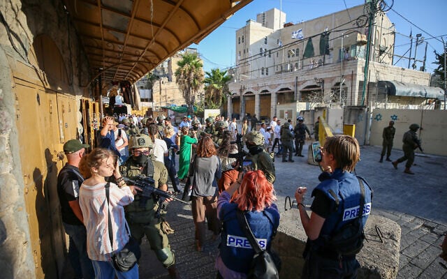 Israeli forces block reporters during a settler march through the southern West Bank city of Hebron on August 29, 2026. (Wisam Hashlamoun / Anadolu via Reuters)