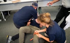 Community Security Service (CSS) volunteers practice applying a tourniquet, in Westchester County, New York, August 13, 2026. (Luke Tress/Times of Israel)