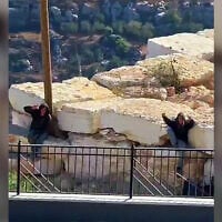 Settlers gesture to the camera as they remain outside the besieged homes of Palestinian residents in Qusra, near Nablus in the northern West Bank, August 13, 2026 (Video screenshot; used in accordance with Clause 27a of the Copyright Law)