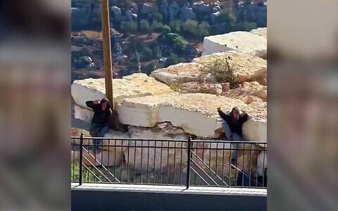 Settlers gesture to the camera as they remain outside the besieged homes of Palestinian residents in Qusra, near Nablus in the northern West Bank, August 13, 2026 (Video screenshot; used in accordance with Clause 27a of the Copyright Law)