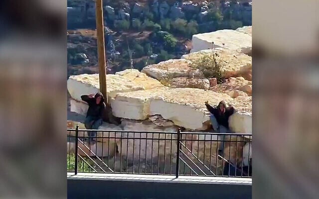 Settlers gesture to the camera as they remain outside the besieged homes of Palestinian residents in Qusra, near Nablus in the northern West Bank, August 13, 2026 (Video screenshot; used in accordance with Clause 27a of the Copyright Law)