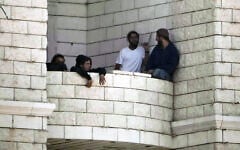 Settlers who raided a Palestinian village gather on the balcony of a building under construction in the West Bank's Qusra, August 29, 2026. (AP Photo/Majdi Mohammed)