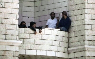 Settlers who raided a Palestinian village gather on the balcony of a building under construction in the West Bank's Qusra, August 29, 2026. (AP/Majdi Mohammed) Settlers who raided a Palestinian village gather on the balcony of a building under construction in the West Bank's Qusra, August 29, 2026. (AP/Majdi Mohammed)