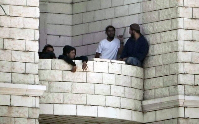 Settlers who raided a Palestinian village gather on the balcony of a building under construction in the West Bank's Qusra, August 29, 2026. (AP Photo/Majdi Mohammed)