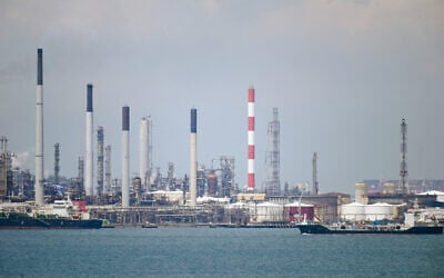 Illustrative: An oil tanker (R) sails past petroleum refineries on Bukom Island off Singapore on March 17, 2022. (Roslan RAHMAN/AFP)