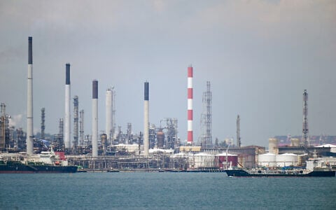 Illustrative: An oil tanker (R) sails past petroleum refineries on Bukom Island off Singapore on March 17, 2022. (Roslan RAHMAN/AFP)