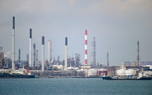 Illustrative: An oil tanker (R) sails past petroleum refineries on Bukom Island off Singapore on March 17, 2022. (Roslan RAHMAN/AFP)