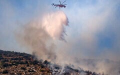 A firefighting helicopter drops water on a wildfire in Haidari, a suburb west of Athens, on July 31, 2026. (Aris Oikonomou/AFP)