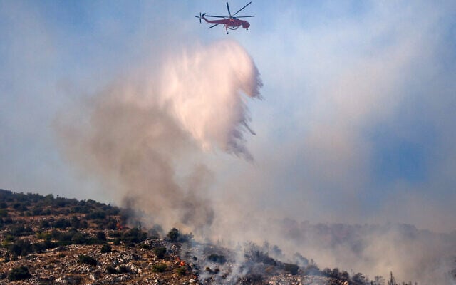 A firefighting helicopter drops water on a wildfire in Haidari, a suburb west of Athens, on July 31, 2026. (Aris Oikonomou/AFP)