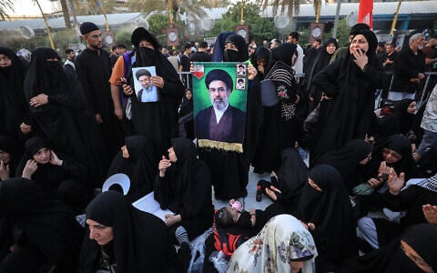 Shia Muslim pilgrims hold the portrait of Iran’s Supreme Leader Mojtaba Khamenei (C) at the Bayn al-Haramayn or 'between the two sanctuaries,' a 378-meter open marble-paved avenue linking the Imam Hussein Shrine and Imam al-Abbas Shrine, in the holy city of Karbala, south of Baghdad, Iraq, on July 31, 2026, at the end of their Arbaeen pilgrimage. (Karar Jabbar/AFP)