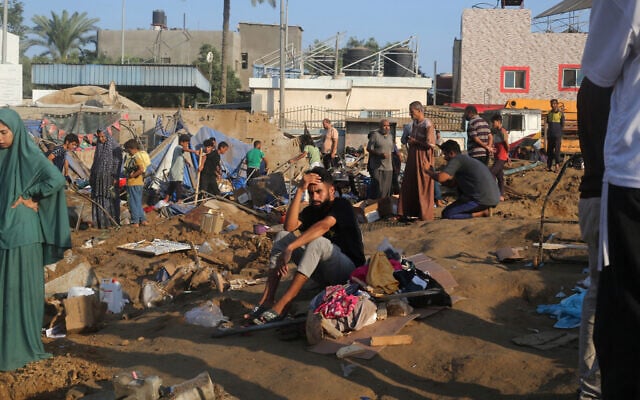 A man sits among the wreckage of tents following an Israeli airstrike that allegedly targeted a nearby medical equipment warehouse of al-Aqsa Martyrs Hospital, in the central Gaza Strip's Deir al-Balah on August 1, 2026. (Eyad Baba/AFP)