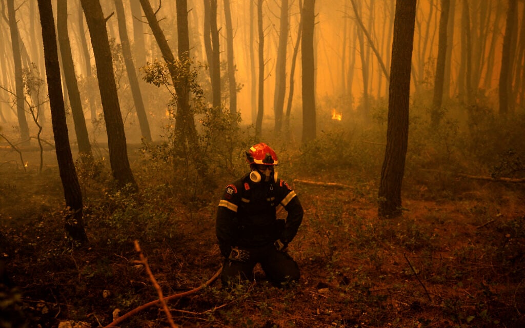 A Greek firefighter rests during a wildfire in the area of Porto Germeno, some 70 kilometers (45 miles) northwest of Athens in the region of Viotia, on August 1, 2026. (Angelos TZORTZINIS/AFP)