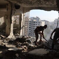 Palestinian residential salvage what they can from an apartment targeted in overnight Israeli airstrikes in Gaza City on August 2, 2026. (Omar AL-QATTAA/AFP)