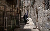 A Greek Orthodox Christian priest walks along an alley in the old city of Jerusalem on August 4, 2026. (Ilia Yefimovich/AFP)