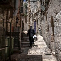 A Greek Orthodox Christian priest walks along an alley in the old city of Jerusalem on August 4, 2026. (Ilia Yefimovich/AFP)