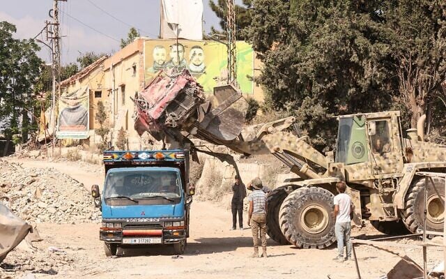 A Lebanese army bulldozer removes the wreckage of a car in the southern Lebanese village of Zawtar al-Gharbiyah on August 8, 2026, following an Israeli withdrawal from the area. (MAHMOUD ZAYYAT/AFP)