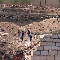Israeli settlers gather in front of Palestinian houses in the village of Qusra, south of Nablus, in the West Bank, on August 12, 2026. (Zain JAAFAR/AFP)