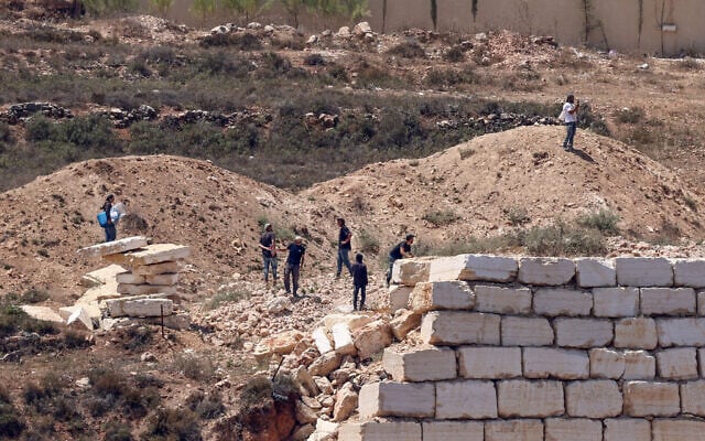 Israeli settlers gather in front of Palestinian houses in the village of Qusra, south of Nablus, in the West Bank, on August 12, 2026. (Zain JAAFAR/AFP)