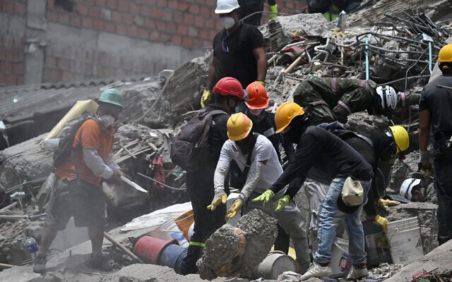 Rescue teams and volunteers search for survivors amid the rubble of a collapsed building following an earthquake in Cali, Colombia, on August 12, 2026. (Raul ARBOLEDA/AFP)