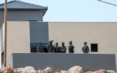 Israeli soldiers take position in a building located adjacent to the home of a Palestinian family besieged by Israeli settlers in the village of Qusra, south of the city Nablus, in the West Bank, on August 14, 2026. (Jaafar ASHTIYEH/AFP)