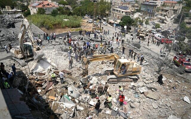 Heavy machinery, first aid responders and residents search the site of an Israeli airstrike that targeted a neighborhood in the southern Lebanese village of Deir al-Zahrani on August 15, 2026. (Abbas FAKIH/AFP)