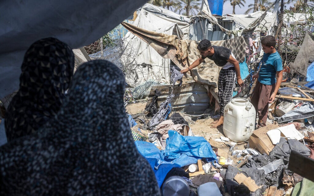 Displaced Palestinians inspect the damage at the site of an alleged Israeli strike on a tent in Khan Yunis, in the southern Gaza Strip, August 16, 2026. (Bashar Taleb/AFP)