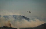 A Mil Mi-8/Mi-17 helicopter flies over a forest during a wildfire on the Greek island of Skyros, in Aegean Sea on August 16, 2026. (Aris MESSINIS/AFP)