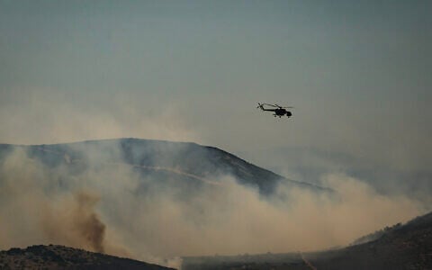 A Mil Mi-8/Mi-17 helicopter flies over a forest during a wildfire on the Greek island of Skyros, in Aegean Sea on August 16, 2026. (Aris MESSINIS/AFP)
