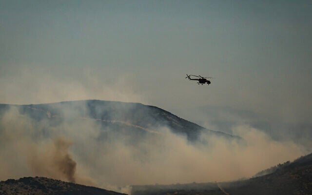 A Mil Mi-8/Mi-17 helicopter flies over a forest during a wildfire on the Greek island of Skyros, in Aegean Sea on August 16, 2026. (Aris MESSINIS/AFP)