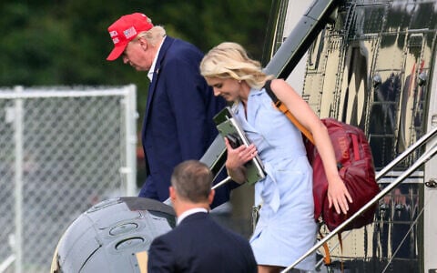 US President Donald Trump and aide Natalie Harp (R) exit Marine One on the Ellipse near the White House on August 16, 2026. (Mandel NGAN/AFP)