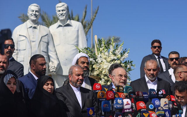 Iran’s Parliament Speaker Mohammad Bagher Ghalibaf, second right, speaks during a press conference in front of a statue showing IRGC Quds Force commander Qassem Soleimani, who was killed by a US airstrike at the site in 2020, near Baghdad's airport on August 19, 2026. (AHMAD AL-RUBAYE/AFP)