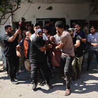 Displaced Palestinians carry victims away from the site of an Israeli strike that targeted police headquarters in Gaza City on August 19, 2026. (Omar AL-QATTAA/AFP)