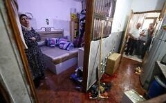 The wife of 58-year-old Fathi Khazem, killed trying to stab a soldier during an arrest operation, stands at the bedroom door near a pool of his blood at their home in the northern city of Jenin, in the West Bank on August 21, 2026. (Jaafar Ashtiyeh/AFP)