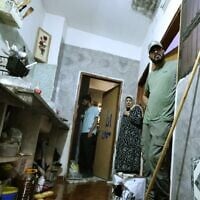 The wife of 58-year-old Fathi Khazem, killed trying to stab a soldier during an arrest operation, stands at the bedroom door with others near a pool of his blood at their home in the northern city of Jenin, in the West Bank on August 21, 2026. (Jaafar Ashtiyeh/AFP)