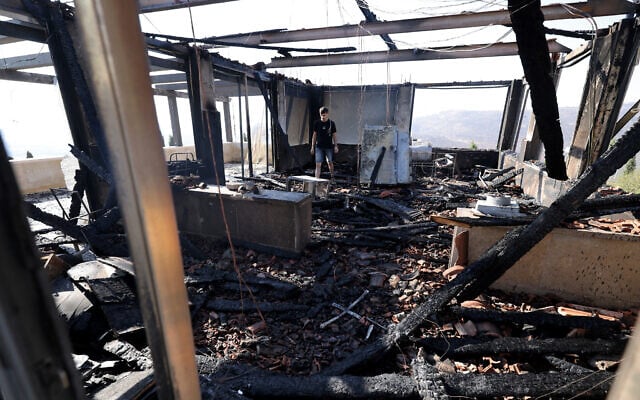 A Palestinian inspects one of the buildings at his home, reportedly set fire and defaced with graffiti by Israeli settlers south of Nablus in the West Bank, on August 23, 2026. (JAAFAR ASHTIYEH/AFP)