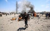 A Palestinian man walks past a burning truck following an Israeli strike, in the area of Maghazi refugee camp, in the central Gaza Strip, on August 23, 2026. (Eyad Baba/AFP)
