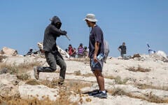 An Israeli settler attacks a left-wing activist at an Israeli outpost in the Palestinian village of Jannatah, just south of the city of Bethlehem on August 25, 2026. (ilia YEFIMOVICH/AFP)