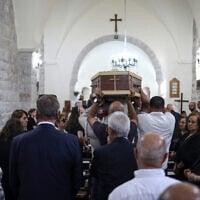 Mourners carry the casket of Palestinian artist Sliman Mansour during his funeral at St. Peter’s Episcopal Church, in the town of Birzeit, north of Ramallah, in the West Bank, on August 26, 2026. (Zain JAAFAR/AFP)