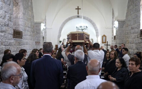 Mourners carry the casket of Palestinian artist Sliman Mansour during his funeral at St. Peter’s Episcopal Church, in the town of Birzeit, north of Ramallah, in the West Bank, on August 26, 2026. (Zain JAAFAR/AFP)