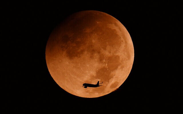 The moon begins the penumbral stage during a partial lunar eclipse over the Israeli coastal city of Netanya on August 28, 2026. (JACK GUEZ/AFP)