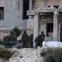 Israeli soldiers remove the body of a Palestinian killed in an air strike from a house under construction, on the western outskirts of the northern city of Jenin, in the West Bank on August 28, 2026. (Jaafar ASHTIYEH/AFP)